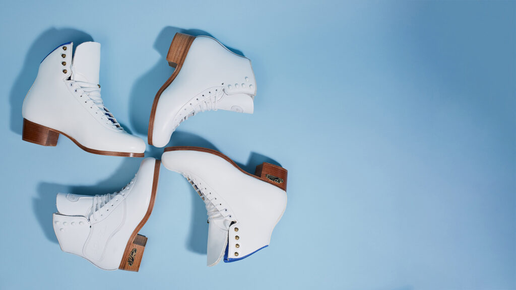 Four pairs of white ice skates with brown heels are arranged in a circular pattern on a light blue background, with the toes pointing inward and the heels outward.