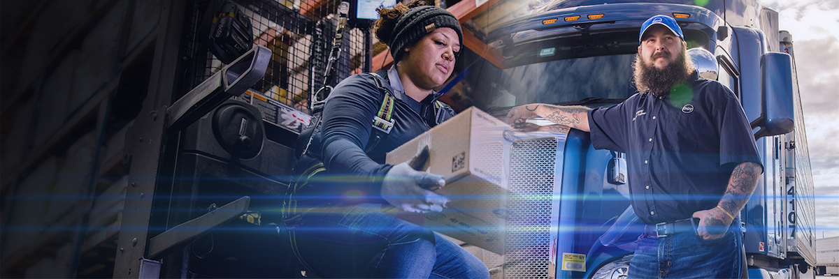 A delivery worker places a package onto a forklift, while another worker with a beard and cap stands beside a blue semi-truck, both wearing work uniforms and safety gear.