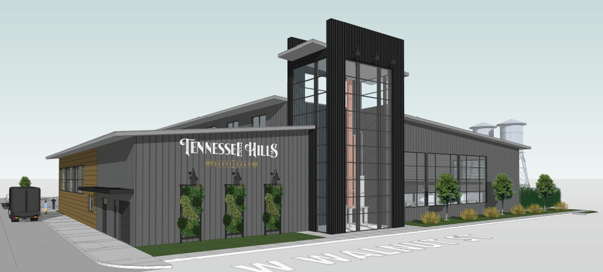 A modern industrial building labeled "Tennessee Hills Distillery" sits on the corner of W Walnut St. The structure features large windows, vertical siding, a tall glass entry, and landscaped greenery along the front.