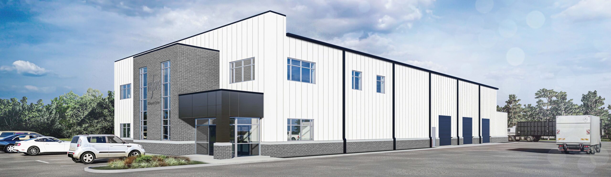 Modern industrial building with white and gray exterior, large windows, and loading bays. Several cars and a truck are parked outside under a partly cloudy sky, with some trees visible in the background.